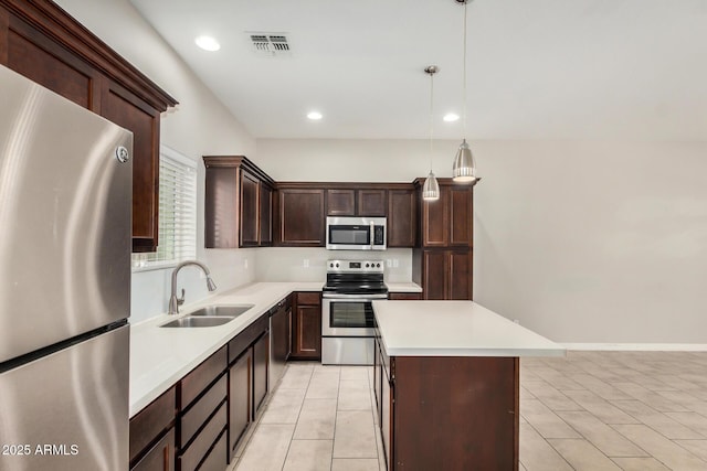 2000 N 36th St Unit 30, Phoenix, AZ 85008 - kitchen with stainless steel appliances, light countertops, a kitchen island, dark brown cabinets, and hanging light fixtures