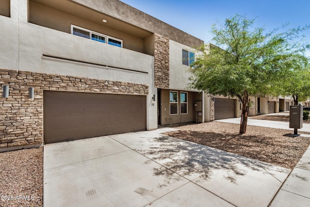 2000 N 36th St Unit 30, Phoenix, AZ 85008 - view of front of home with stone siding, concrete driveway, an attached garage, and stucco siding