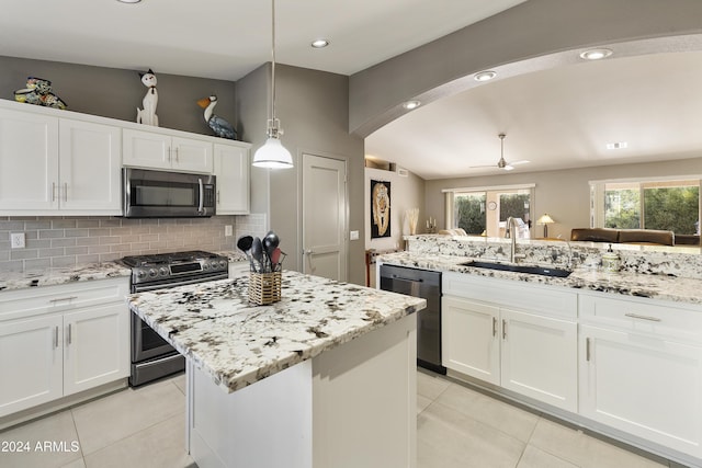 kitchen featuring appliances with stainless steel finishes, decorative backsplash, hanging light fixtures, a kitchen island, and white cabinets