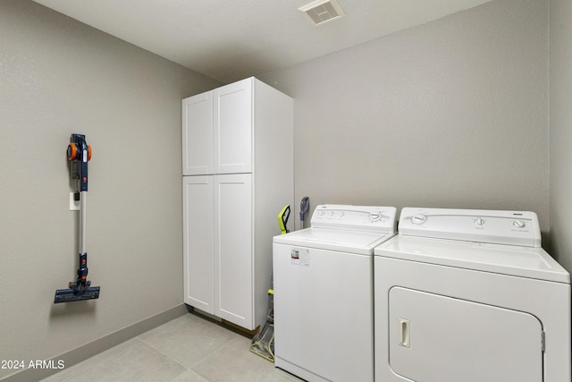 laundry area featuring washing machine and dryer and cabinets