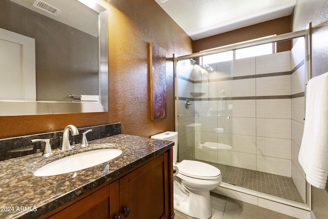 bathroom featuring toilet, walk in shower, tile patterned floors, and vanity