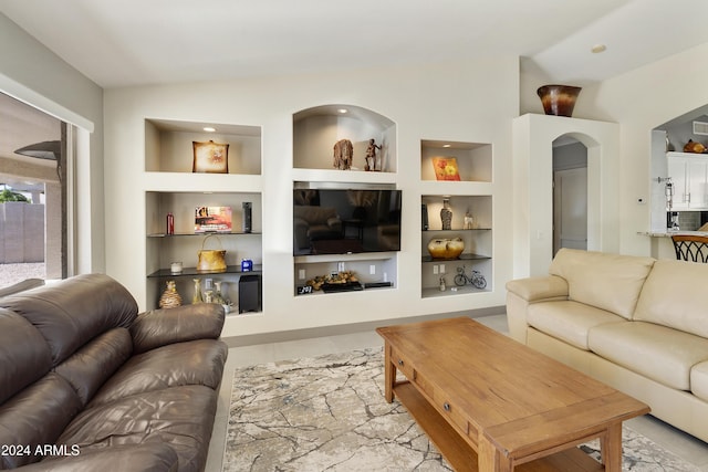 living room featuring lofted ceiling and built in features