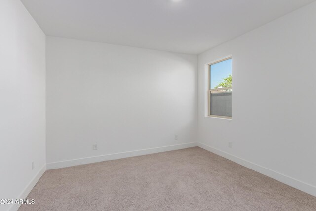 spare room featuring light colored carpet