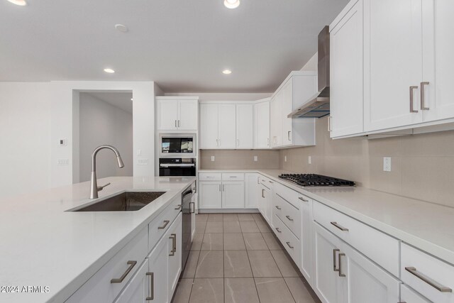 kitchen featuring white cabinets, light tile patterned floors, sink, wall chimney range hood, and black appliances