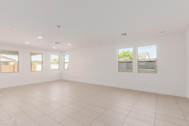 unfurnished room with a wealth of natural light and light tile patterned floors