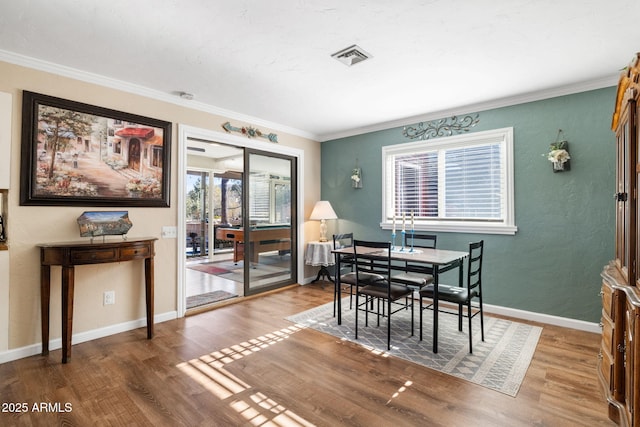 dining room with hardwood / wood-style flooring and ornamental molding