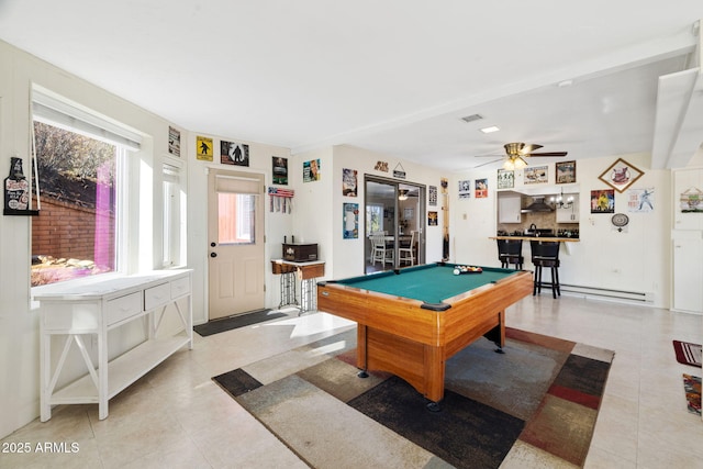 recreation room with bar, pool table, light tile patterned floors, ceiling fan, and a baseboard heating unit