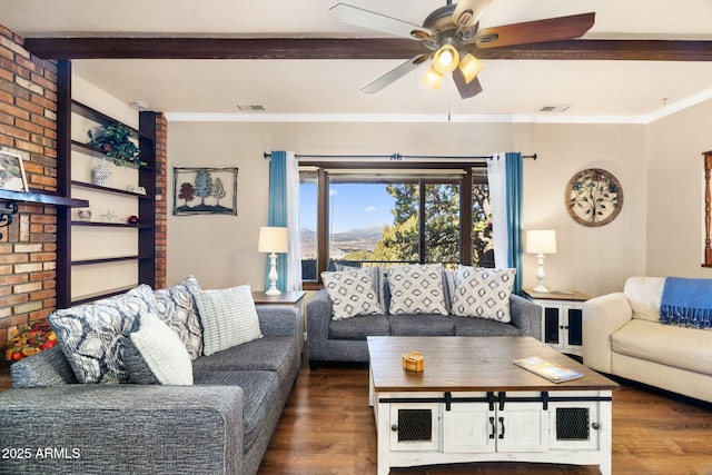 living room featuring beamed ceiling, ornamental molding, dark wood-type flooring, and ceiling fan