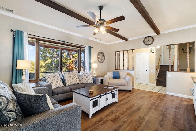 living room featuring beamed ceiling, crown molding, ceiling fan with notable chandelier, and hardwood / wood-style flooring