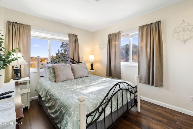 bedroom featuring multiple windows and dark hardwood / wood-style floors