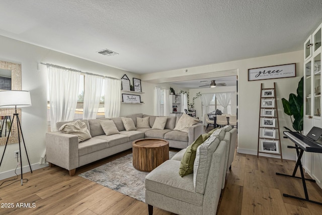 3064 E Michelle Way, Gilbert, AZ 85234 - living room featuring light wood-style floors, a textured ceiling, and ceiling fan