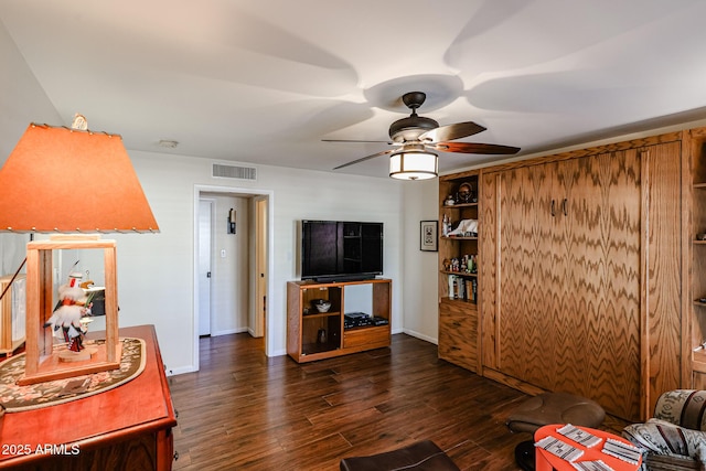 living room with visible vents, dark wood finished floors, baseboards, and ceiling fan