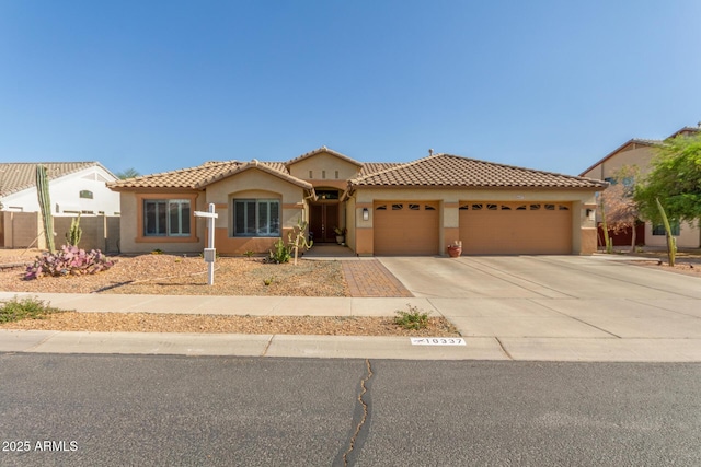 mediterranean / spanish home featuring stucco siding, a tiled roof, and an attached garage