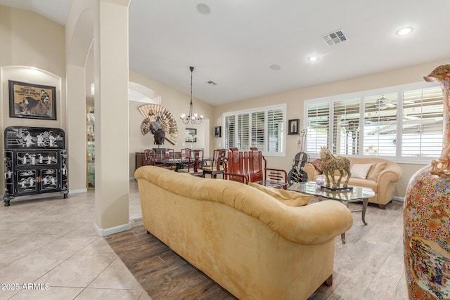 living room with lofted ceiling, recessed lighting, a notable chandelier, and visible vents