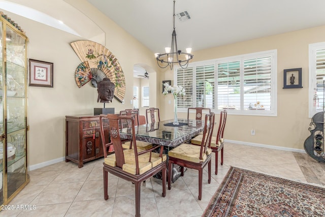 dining room with light tile patterned floors, visible vents, arched walkways, and a notable chandelier