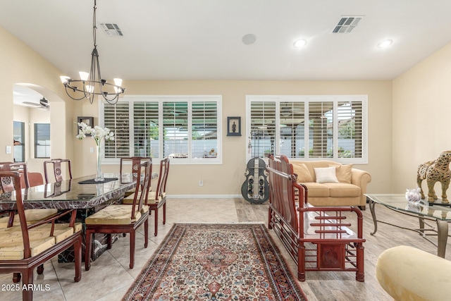dining area featuring baseboards, a notable chandelier, visible vents, and arched walkways