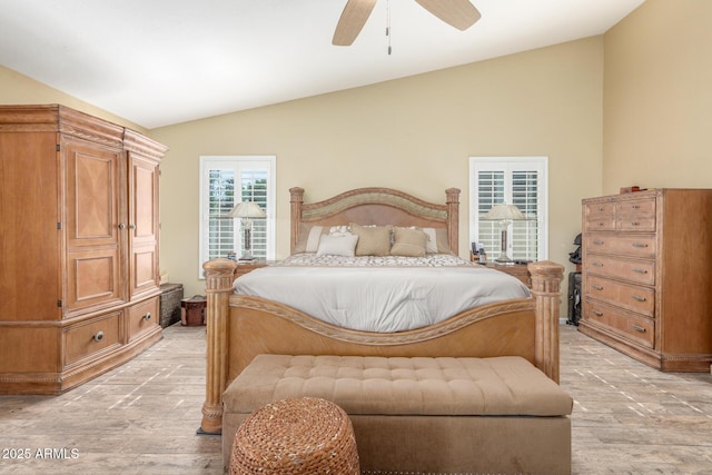 bedroom featuring lofted ceiling, light wood-style flooring, and ceiling fan