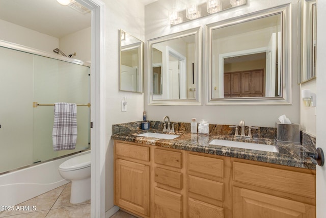 bathroom featuring toilet, visible vents, bath / shower combo with glass door, and a sink