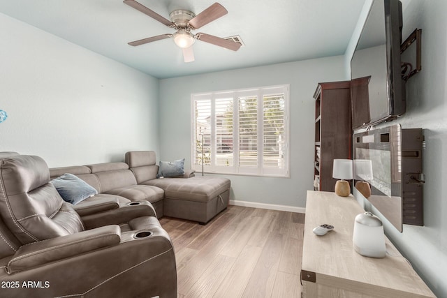 living area with light wood-style floors, visible vents, baseboards, and ceiling fan