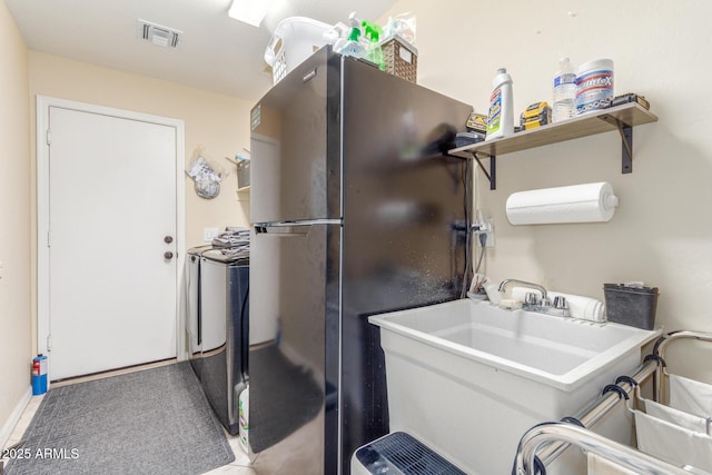 laundry area featuring washing machine and clothes dryer and visible vents