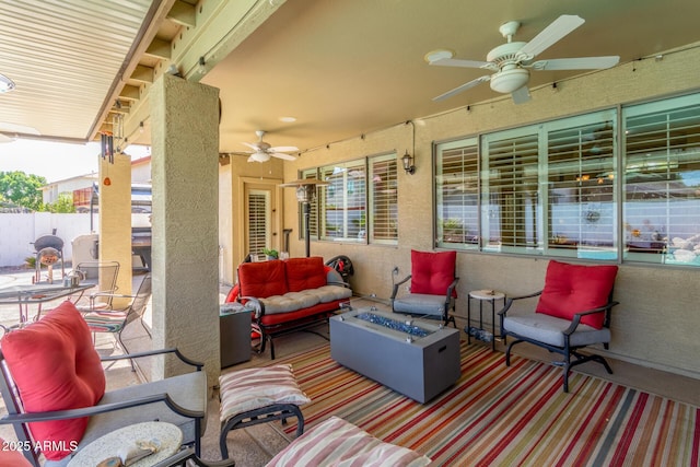 view of patio / terrace with an outdoor living space with a fire pit, ceiling fan, and fence