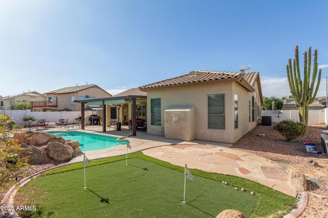 back of property featuring a tiled roof, a patio, stucco siding, and a fenced backyard