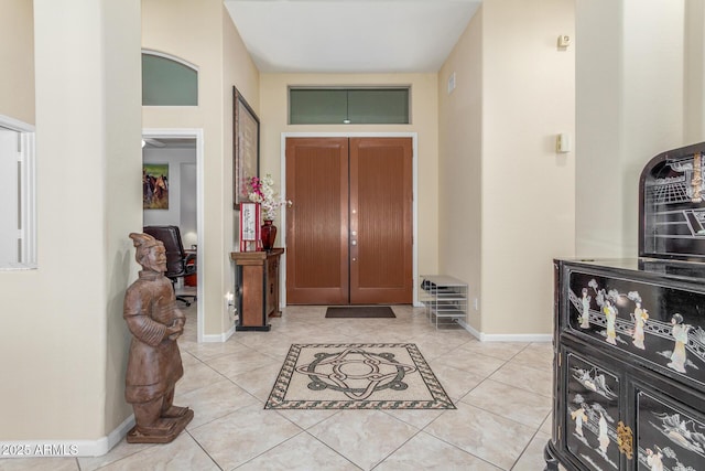 entryway featuring baseboards and light tile patterned flooring