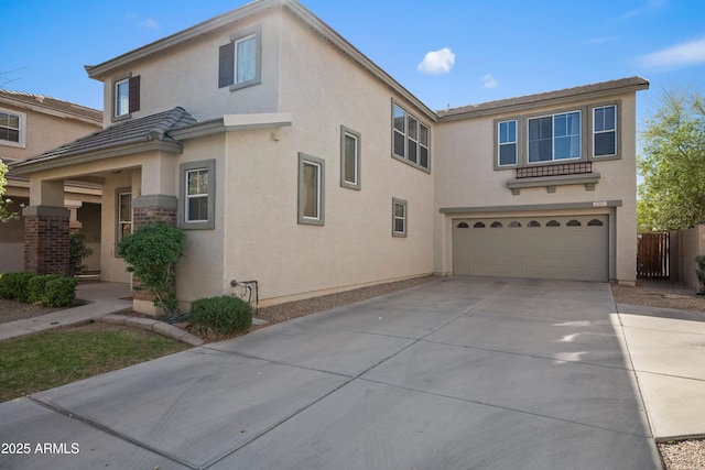 view of front of home with a garage, driveway, and stucco siding