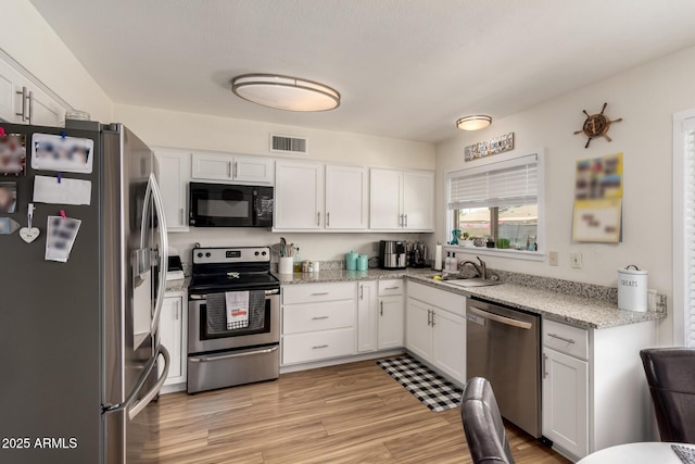 3447 E Dolphin Ave, Mesa, AZ 85204 - kitchen with appliances with stainless steel finishes, white cabinetry, light stone counters, and light wood-style floors