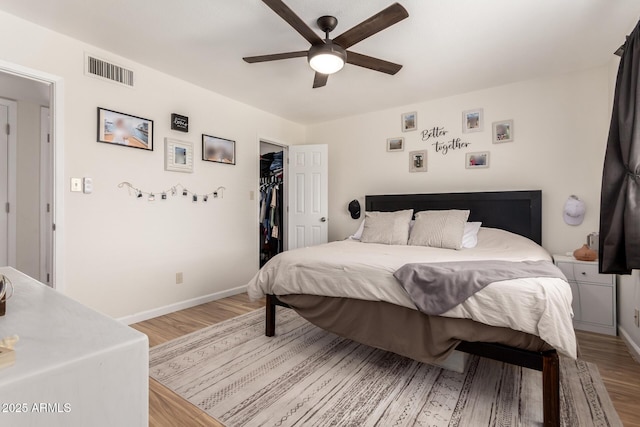 3447 E Dolphin Ave, Mesa, AZ 85204 - bedroom with light wood-type flooring, a walk in closet, a ceiling fan, and a closet