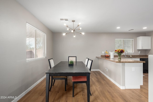 dining room featuring light hardwood / wood-style floors, a notable chandelier, and sink