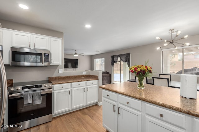 kitchen featuring stainless steel appliances, plenty of natural light, and white cabinets