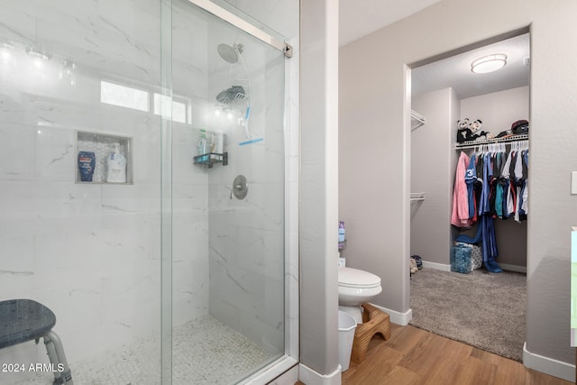 bathroom featuring wood-type flooring, walk in shower, and toilet