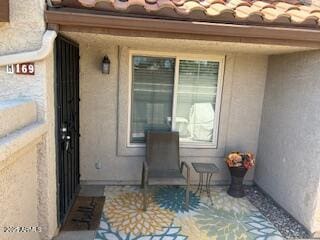 property entrance with stucco siding and a tile roof