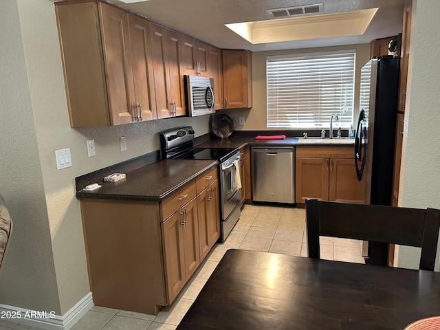 kitchen featuring visible vents, a sink, light tile patterned flooring, and stainless steel appliances
