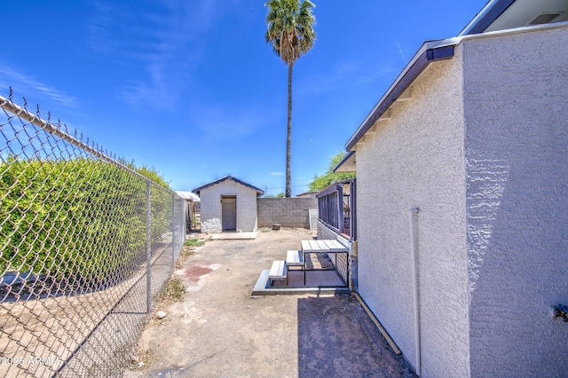 552 E 8th St, Florence, AZ 85132 - view of side of home with an outbuilding, a storage unit, a fenced backyard, and stucco siding