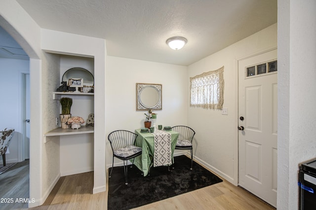 552 E 8th St, Florence, AZ 85132 - dining area with baseboards, arched walkways, a textured ceiling, and wood finished floors