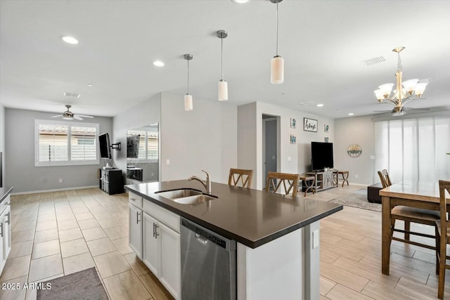 kitchen featuring dishwasher, dark countertops, open floor plan, decorative light fixtures, and white cabinetry