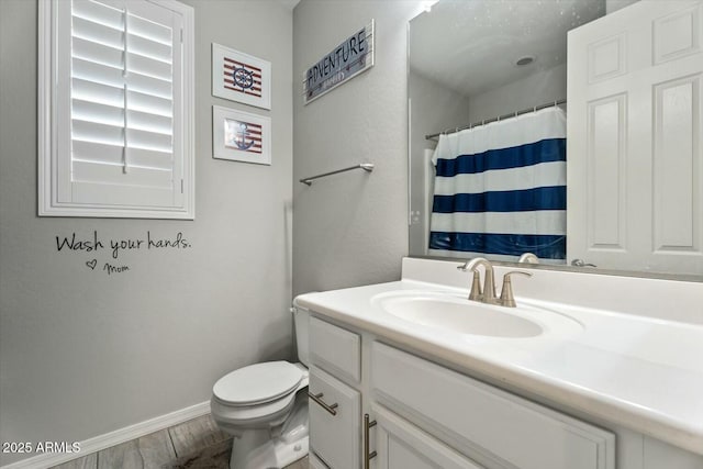 bathroom with baseboards, toilet, wood finished floors, curtained shower, and vanity