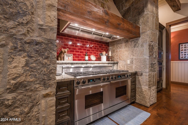 kitchen featuring light stone countertops, dark hardwood / wood-style floors, custom exhaust hood, stainless steel appliances, and dark brown cabinets