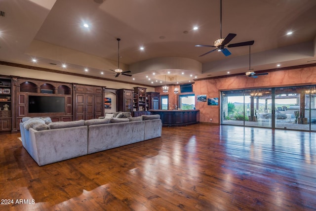 living room featuring ceiling fan, dark hardwood / wood-style floors, and a tray ceiling