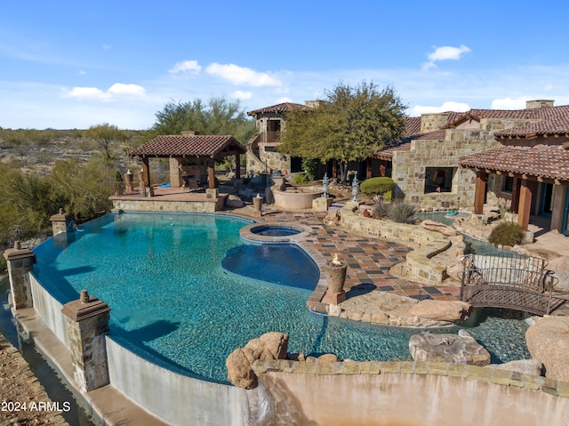 view of pool with exterior fireplace, a patio, and a gazebo