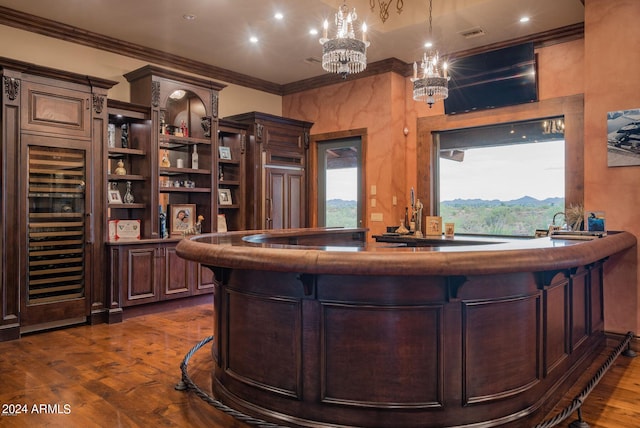 bar with an inviting chandelier, decorative light fixtures, crown molding, and dark hardwood / wood-style floors