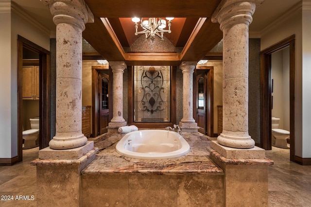 bathroom featuring decorative columns, toilet, and a chandelier