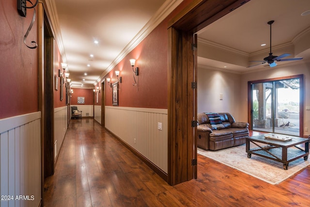 hall with dark wood-type flooring and ornamental molding