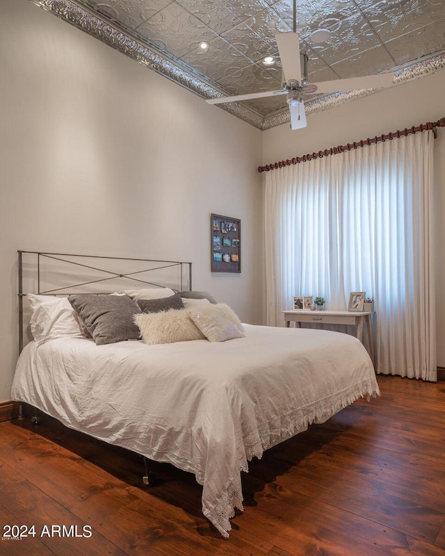 bedroom with dark hardwood / wood-style flooring and ceiling fan