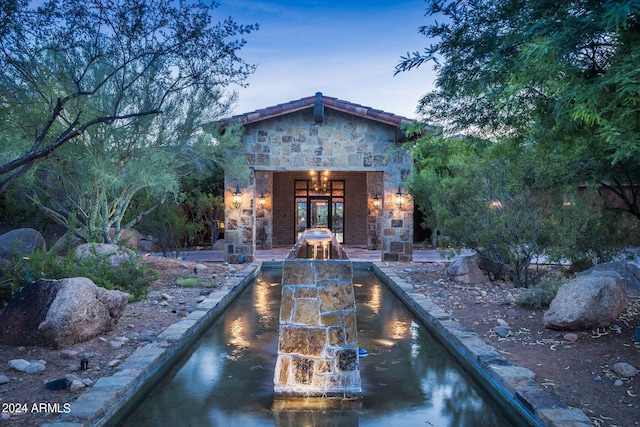 exterior entry at dusk with a patio area