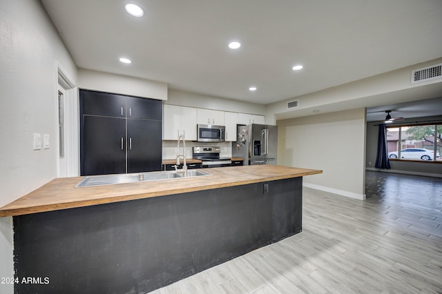 2122 E Radcliffe Dr, Tempe, AZ 85283 - kitchen featuring wood counters, stainless steel appliances, recessed lighting, a peninsula, and light wood-style flooring