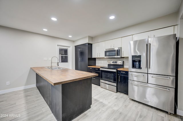 2122 E Radcliffe Dr, Tempe, AZ 85283 - kitchen with appliances with stainless steel finishes, butcher block counters, light wood-style flooring, recessed lighting, and white cabinets