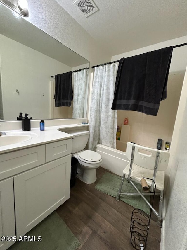 7664 W Vermont Ave, Glendale, AZ 85303 - full bath featuring wood finished floors, vanity, toilet, shower / bath combo with shower curtain, and a textured ceiling